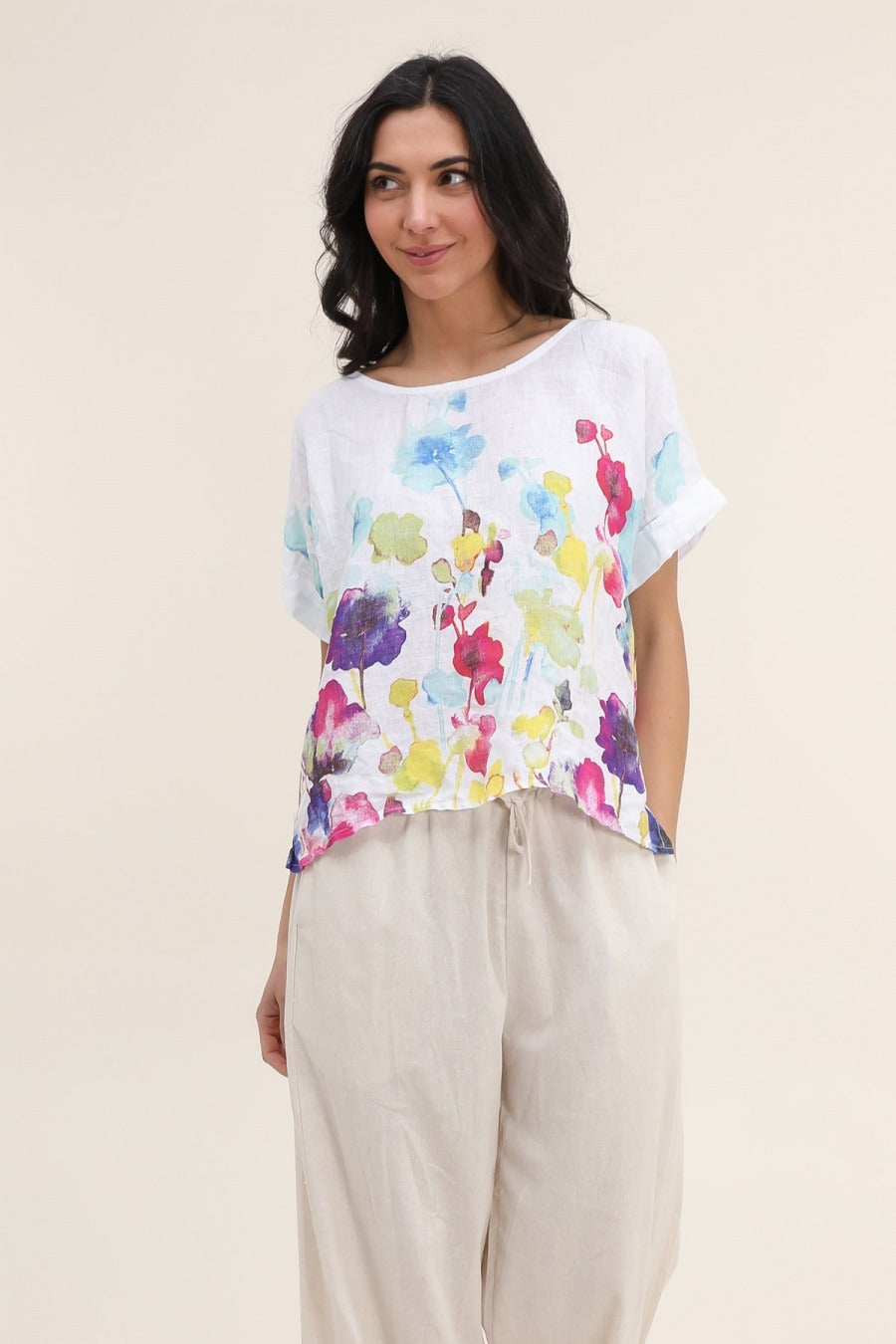 Side view of women's white floral linen blouse with short sleeves and breezy silhouette