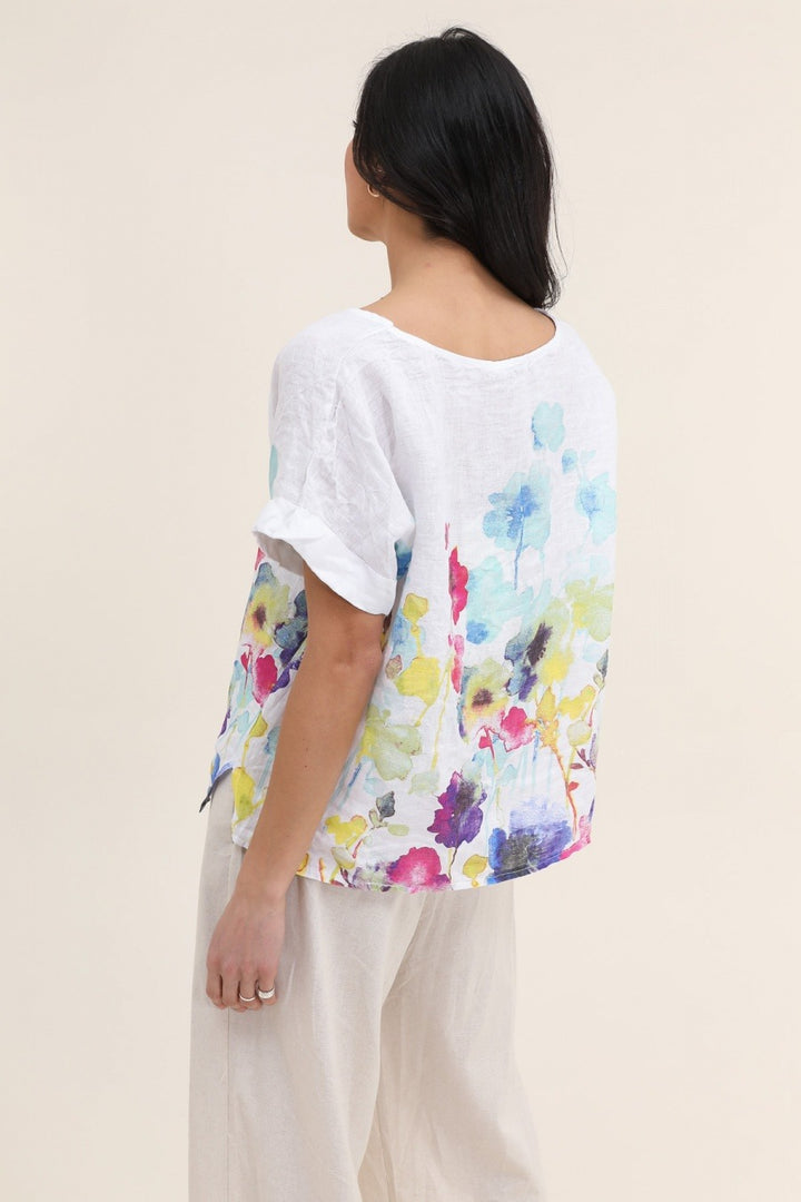 Back view of Italian-made white linen blouse featuring elegant floral design and relaxed fit