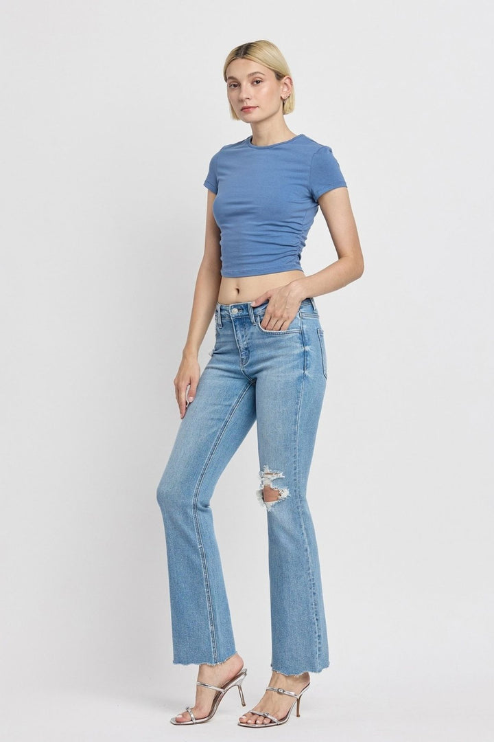 Women's mid-rise bootcut jeans in denim with distressed details and raw hem – full-length fit