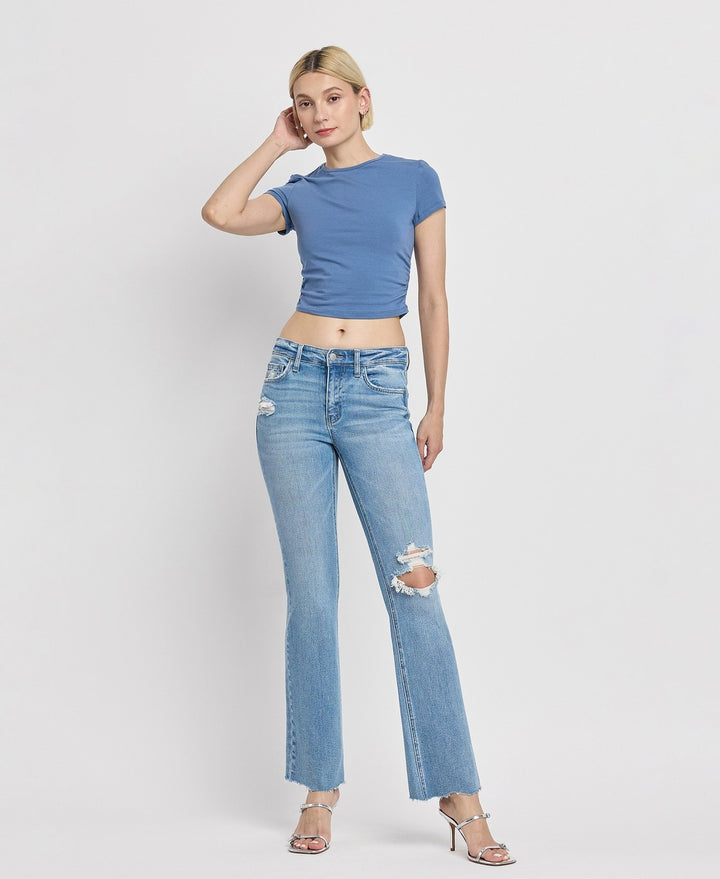 Casual outfit featuring mid-rise bootcut jeans paired with a white blouse and ankle boots