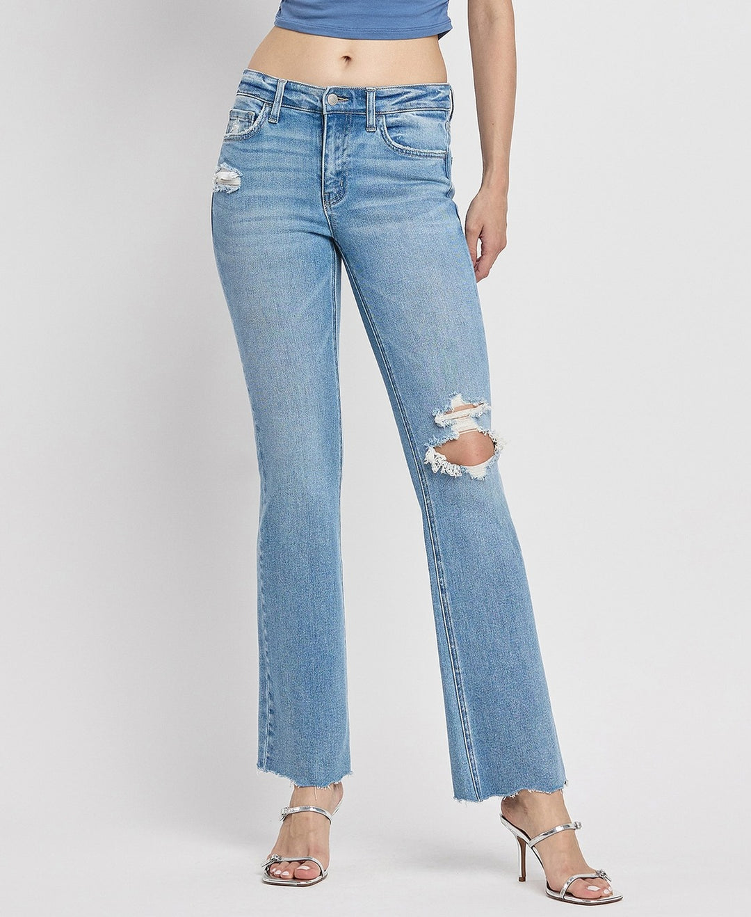 Close-up of stretch denim fabric showcasing distressed texture and raw hem finish