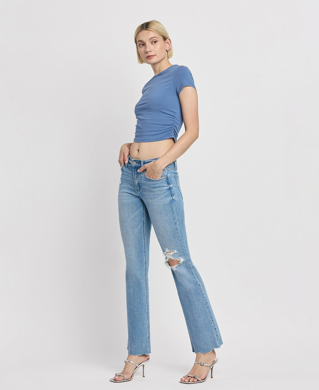 another Side view of women's mid-rise bootcut jeans featuring flattering silhouette and raw hem