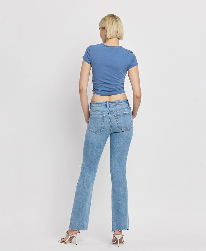 Casual outfit featuring mid-rise bootcut jeans paired with a white blouse and ankle boots