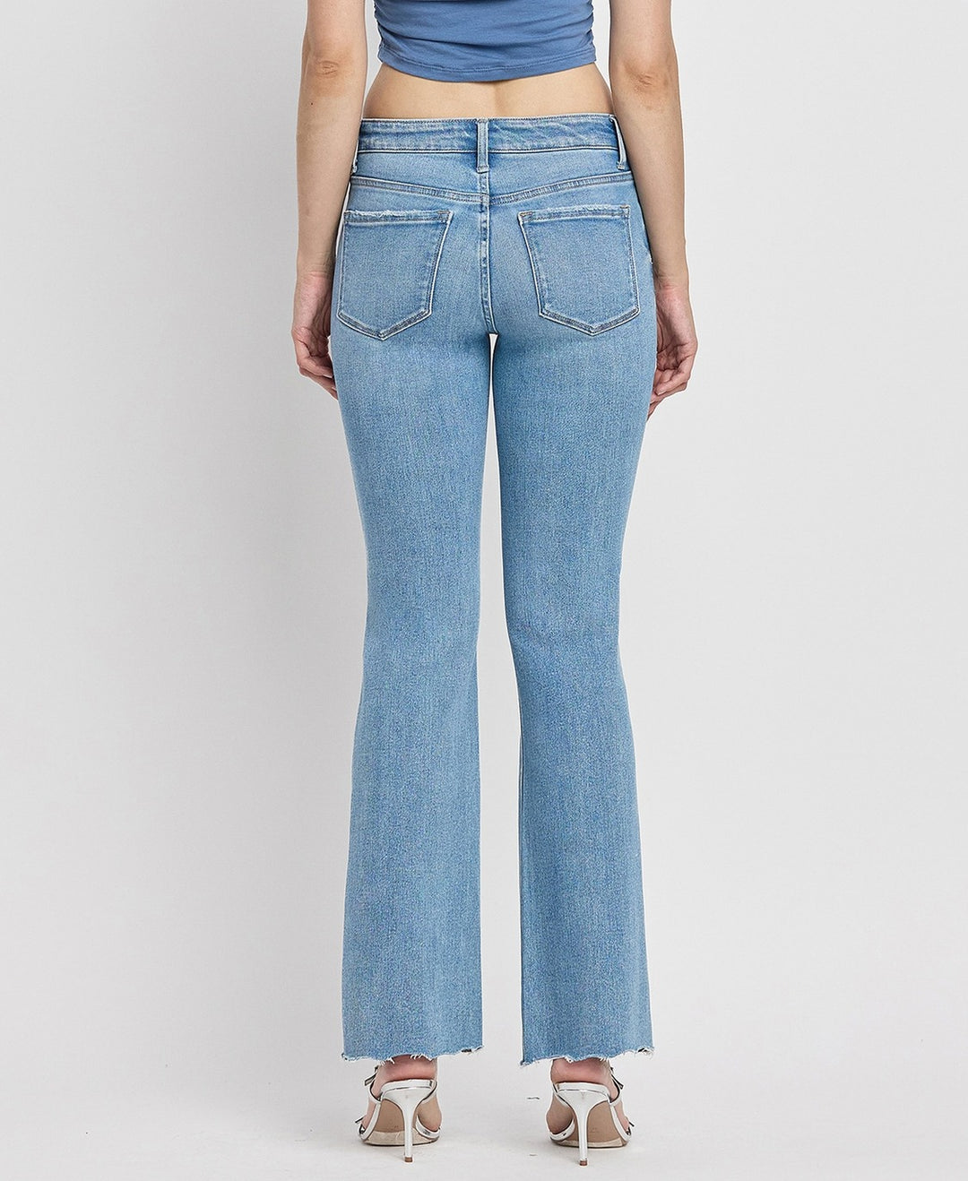 Back view of Italian-made mid-rise bootcut jeans with distressed detailing and full-length cut