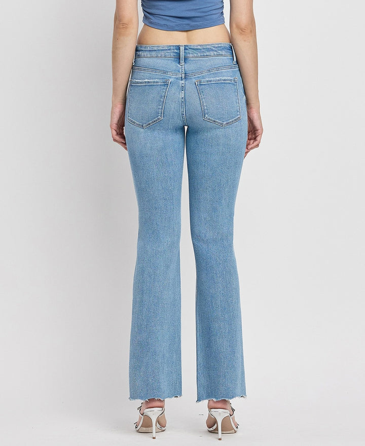 Back view of Italian-made mid-rise bootcut jeans with distressed detailing and full-length cut