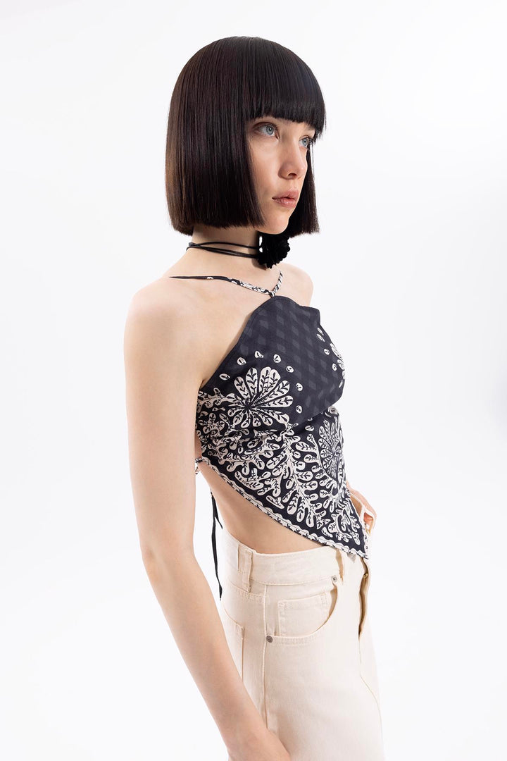 Side view of women's black bandana hem crop top with tie-back design and relaxed fit