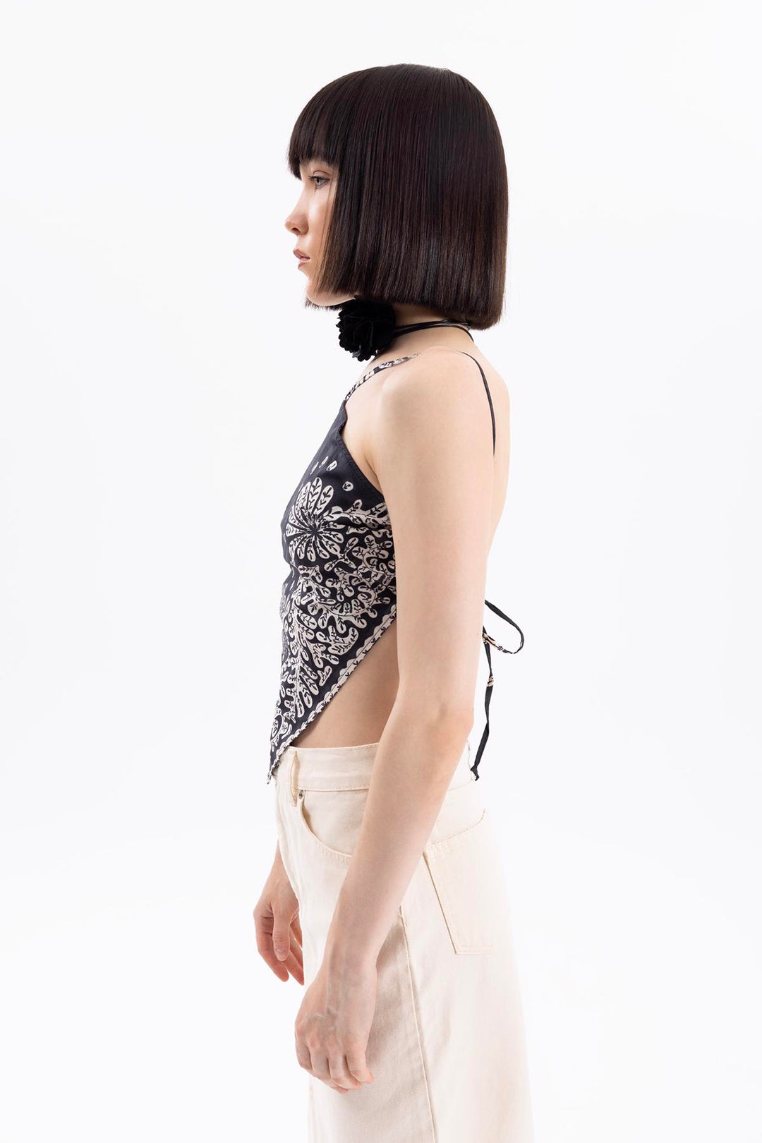 another Side view of women's black bandana hem crop top with tie-back design and relaxed fit
