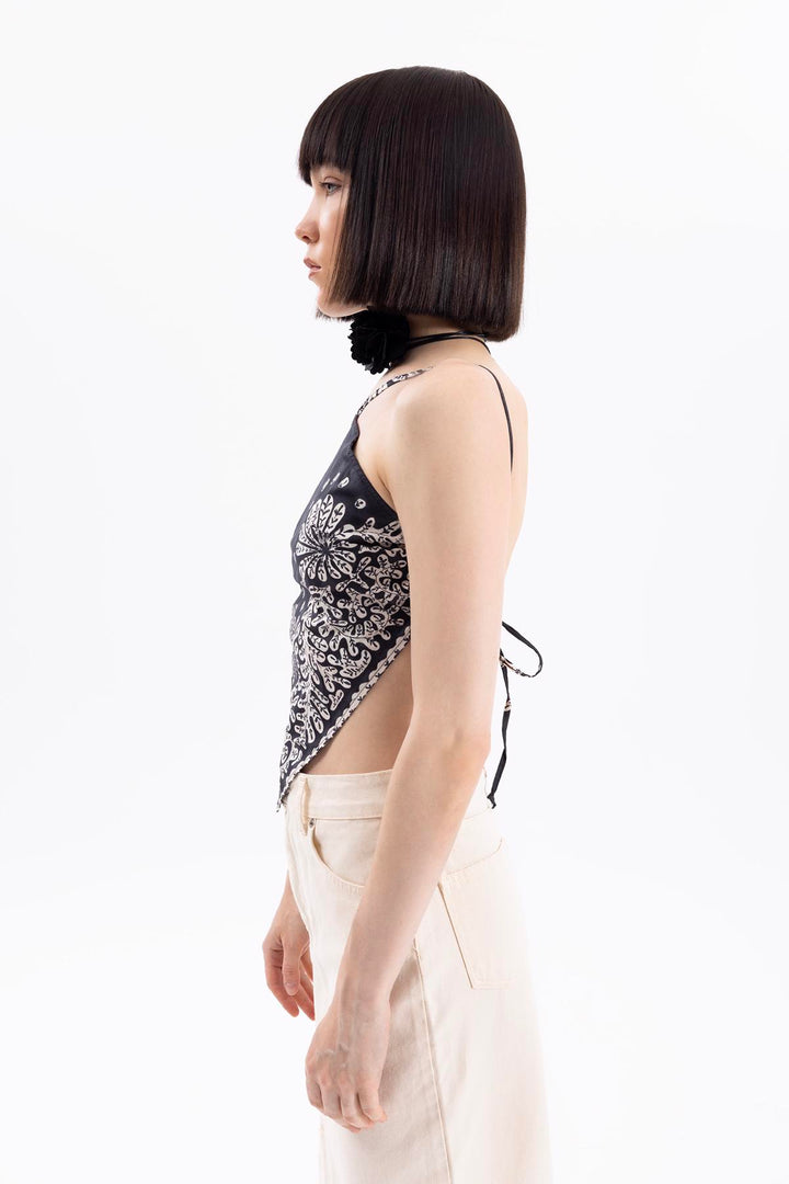 another Side view of women's black bandana hem crop top with tie-back design and relaxed fit