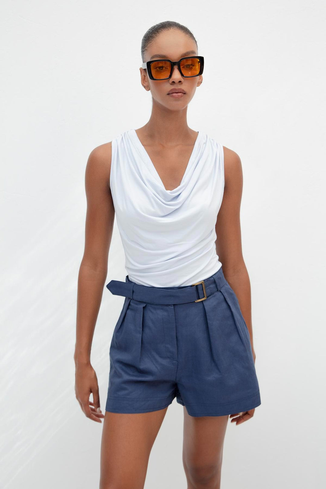Chic outfit pairing light blue ruffle collar top with white trousers – perfect for summer elegance
