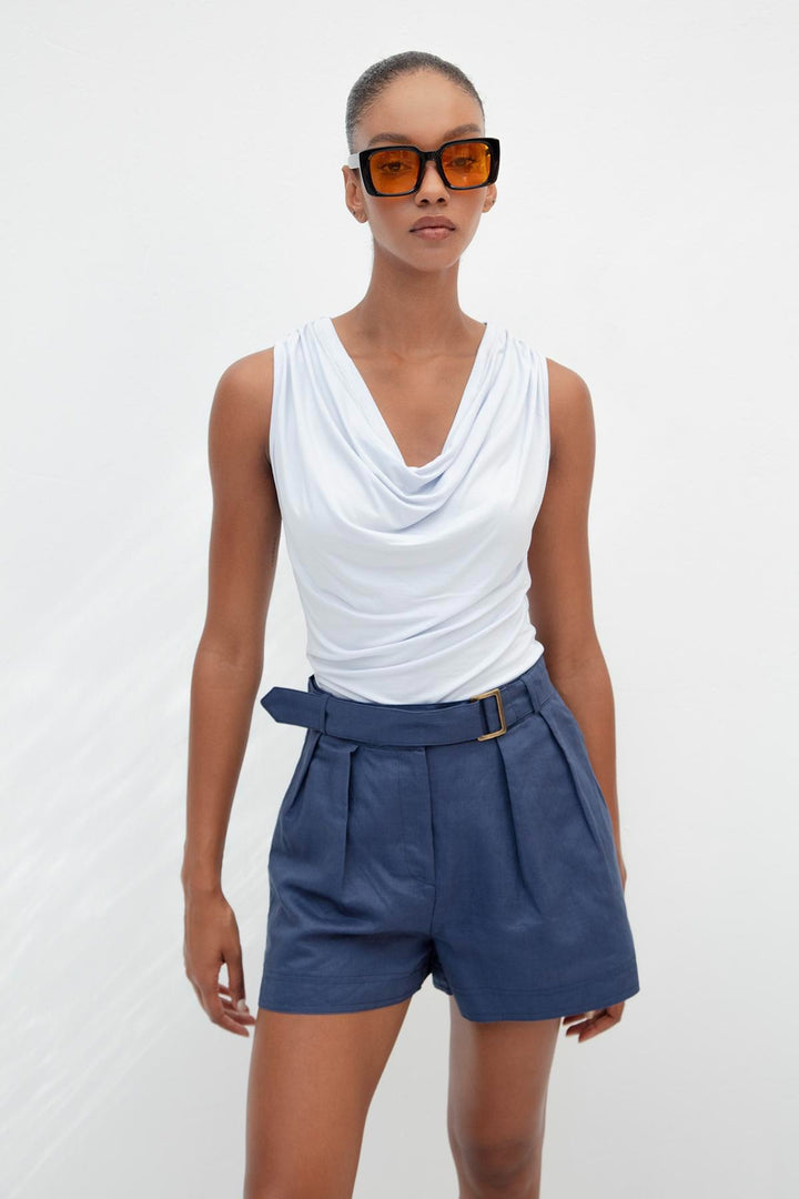 Chic outfit pairing light blue ruffle collar top with white trousers – perfect for summer elegance