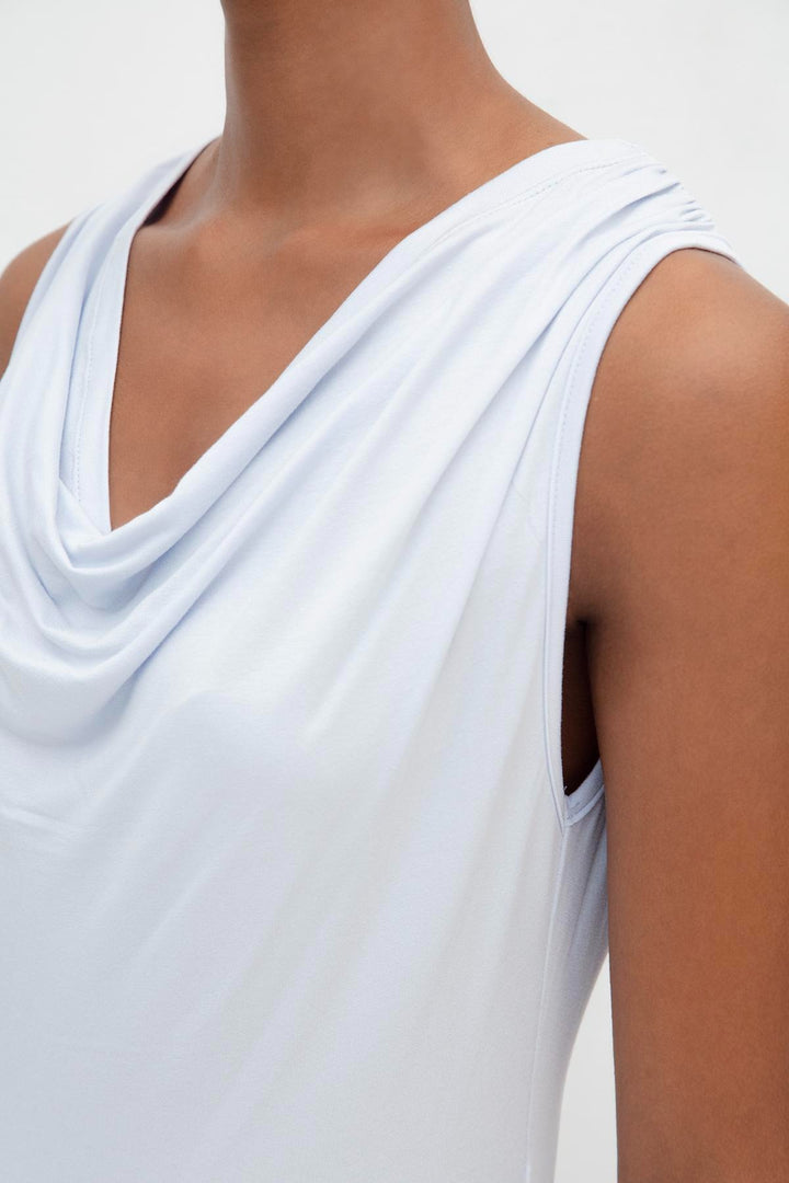 Close-up of 100% viscose fabric in light blue, showcasing smooth texture and ruffle detailing