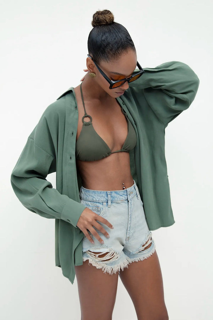 Side view of women's light blue denim shorts featuring mid-rise waist and relaxed fit