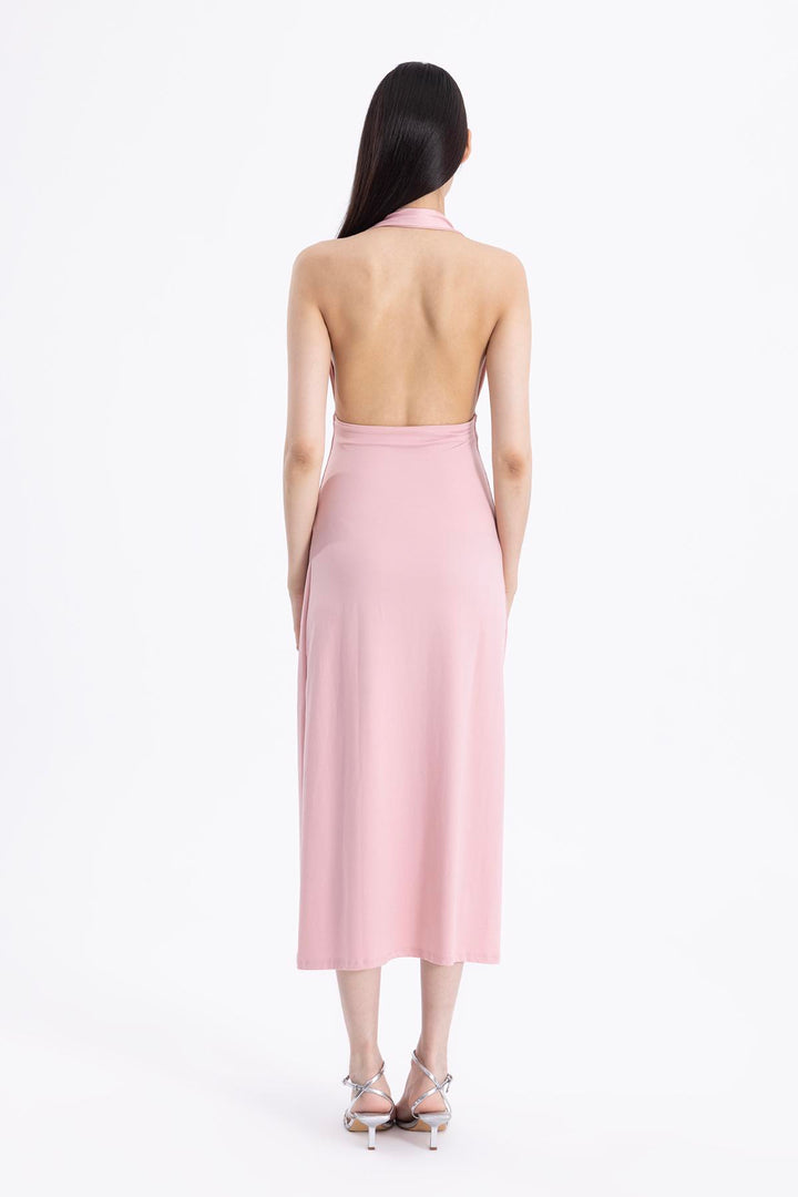 Back view of pink draped midi dress featuring minimal back cut and soft fabric movement