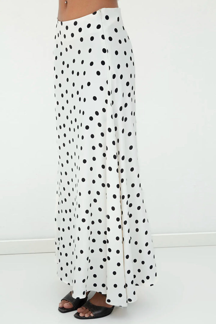 another Side view of ecru satin long skirt with black polka dots, highlighting its elegant drape