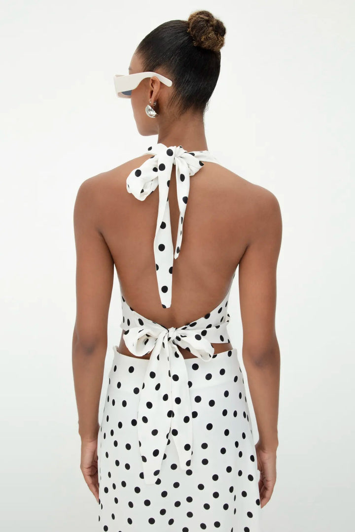 Back view of ecru satin top featuring an open-back design with tie closure and black polka dot pattern