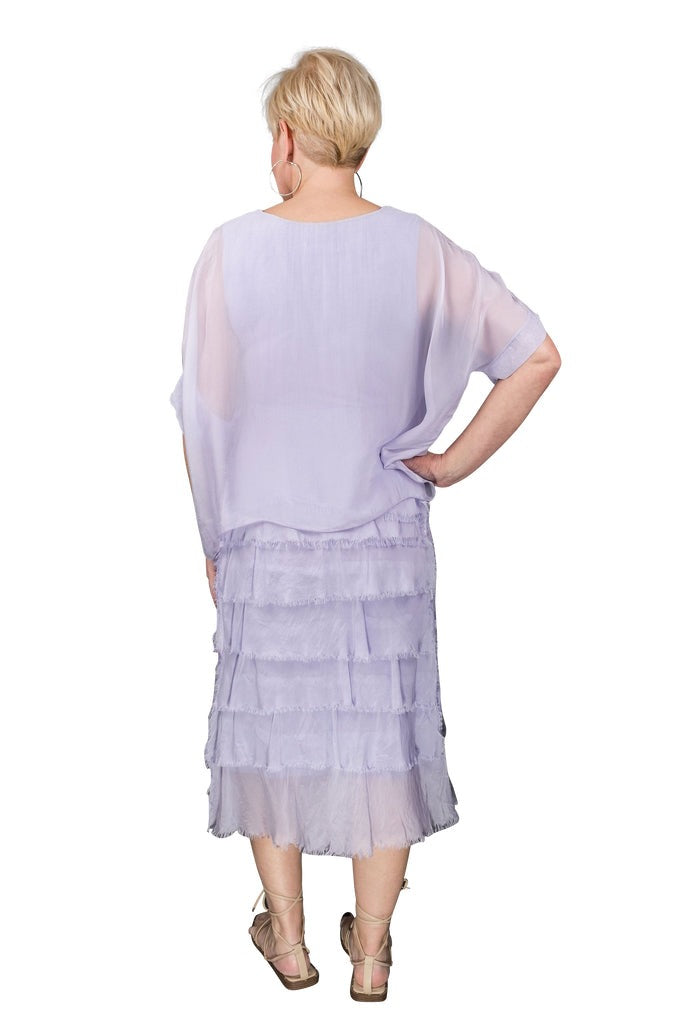 Back view of lilac silk dress featuring tiered structure and breezy, elegant movement
