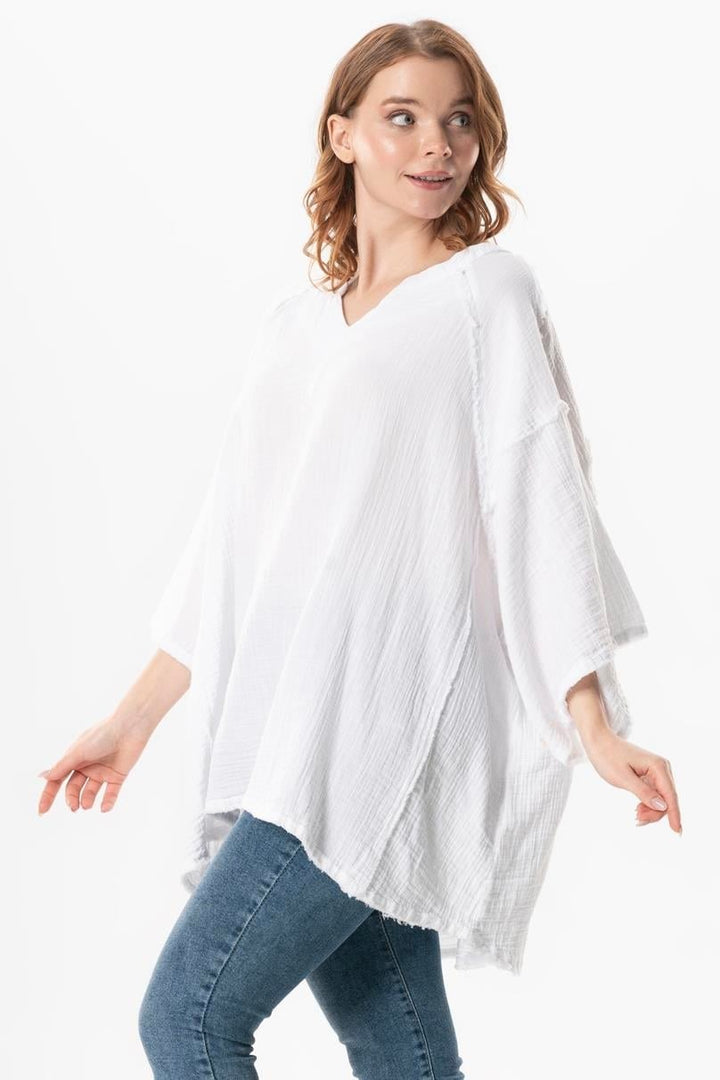 Side view of women's white gauze top with loose silhouette and dropped shoulders