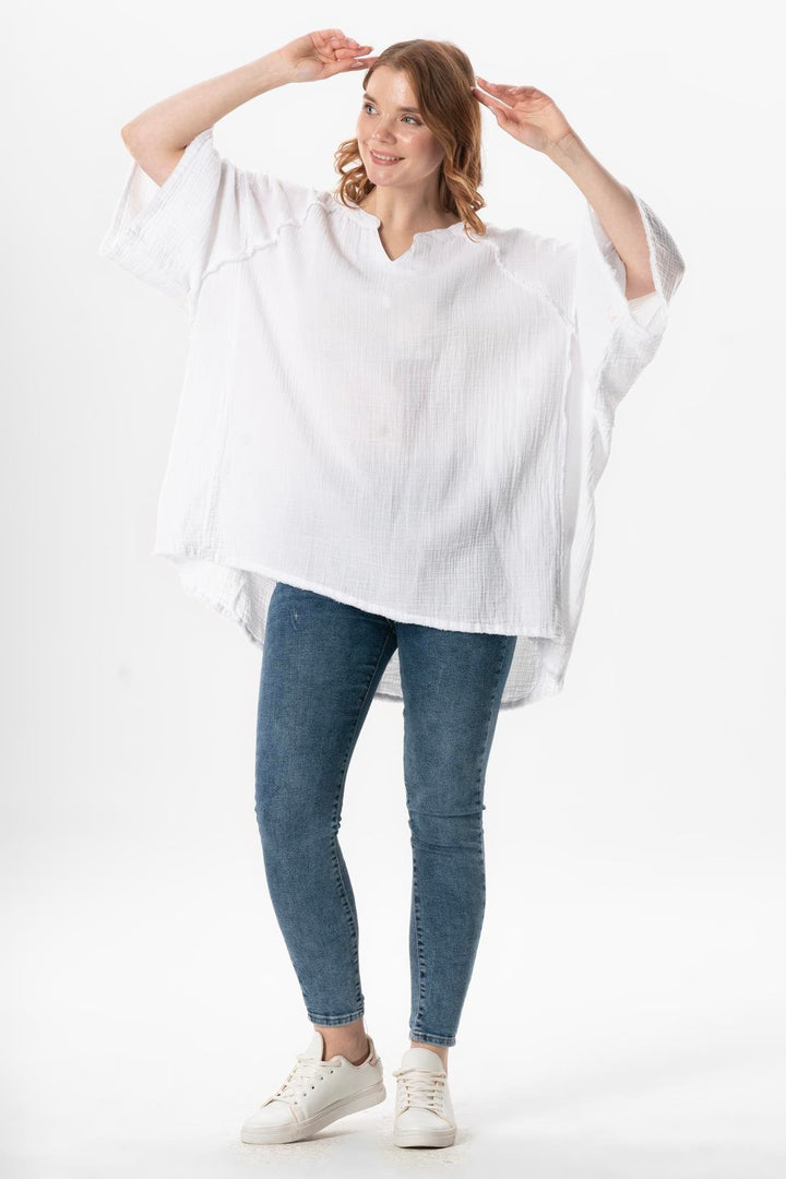 Effortless summer look with white gauze top styled with denim shorts and sandals – airy chic