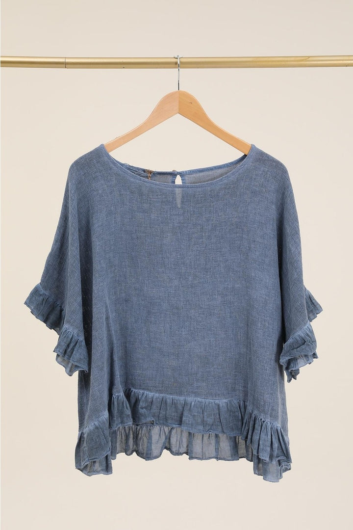 Casual outfit featuring dark blue Italian linen blouse paired with white trousers – effortless elegance