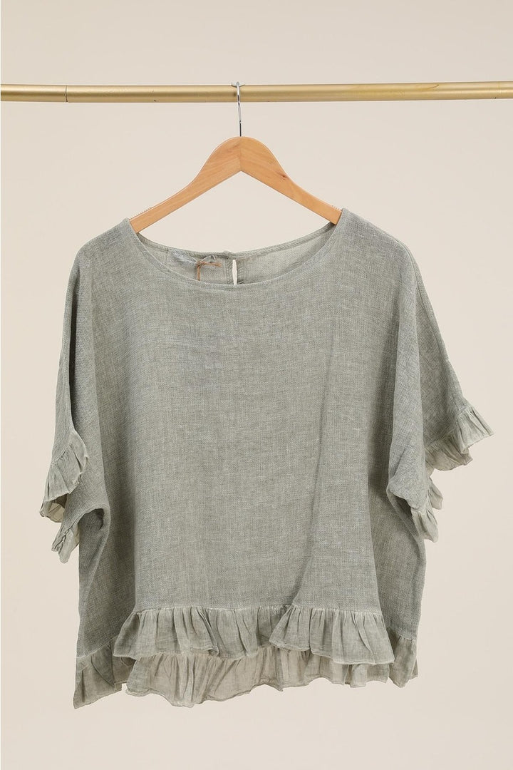 Casual outfit featuring light green Italian linen blouse paired with white trousers – effortless elegance