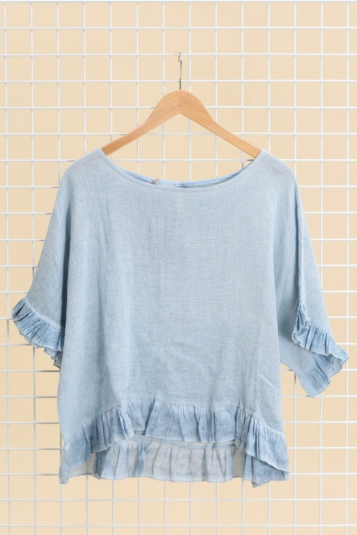 Casual outfit featuring blue Italian linen blouse paired with white trousers – effortless elegance