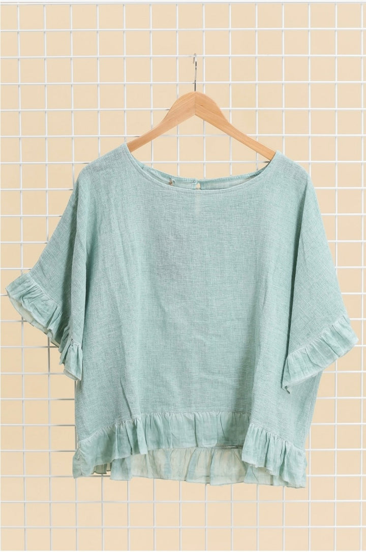 Casual outfit featuring light green Italian linen blouse paired with white trousers – effortless elegance