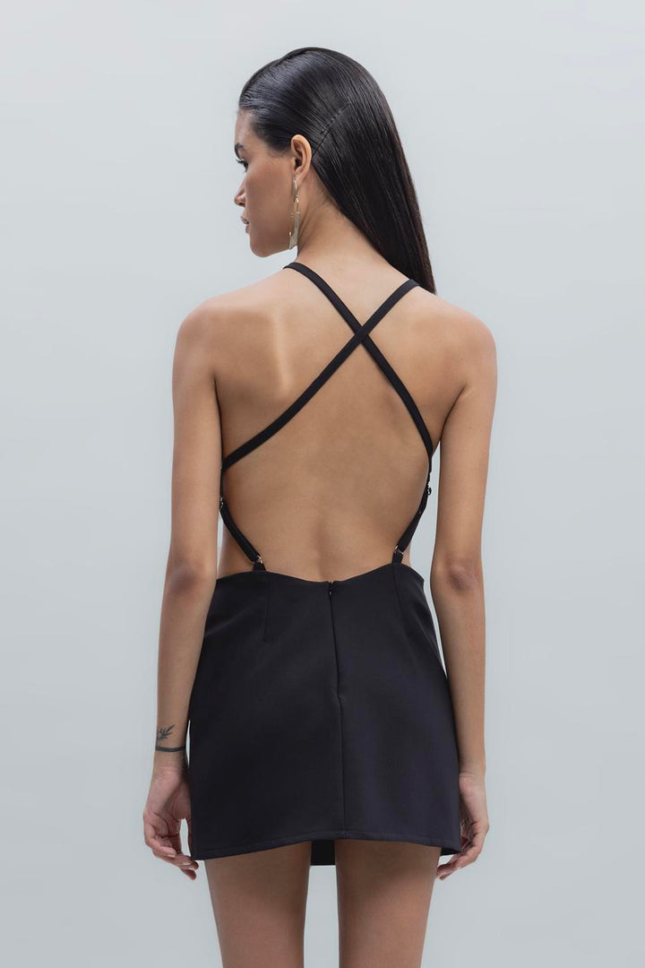 Back view of black mini dress featuring bold criss-cross strap design and open back detail