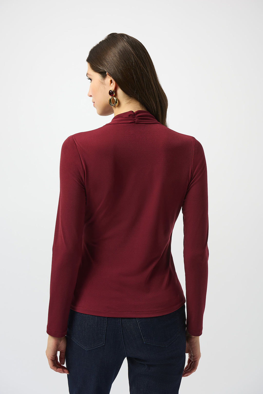 Woman wearing a burgundy long-sleeve top on a white background