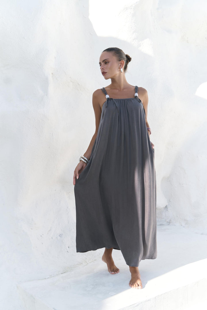 Woman wearing a gray dress standing against a white background