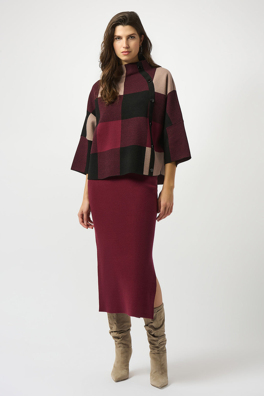 Woman wearing a burgundy and black checkered top with a matching skirt on a white background