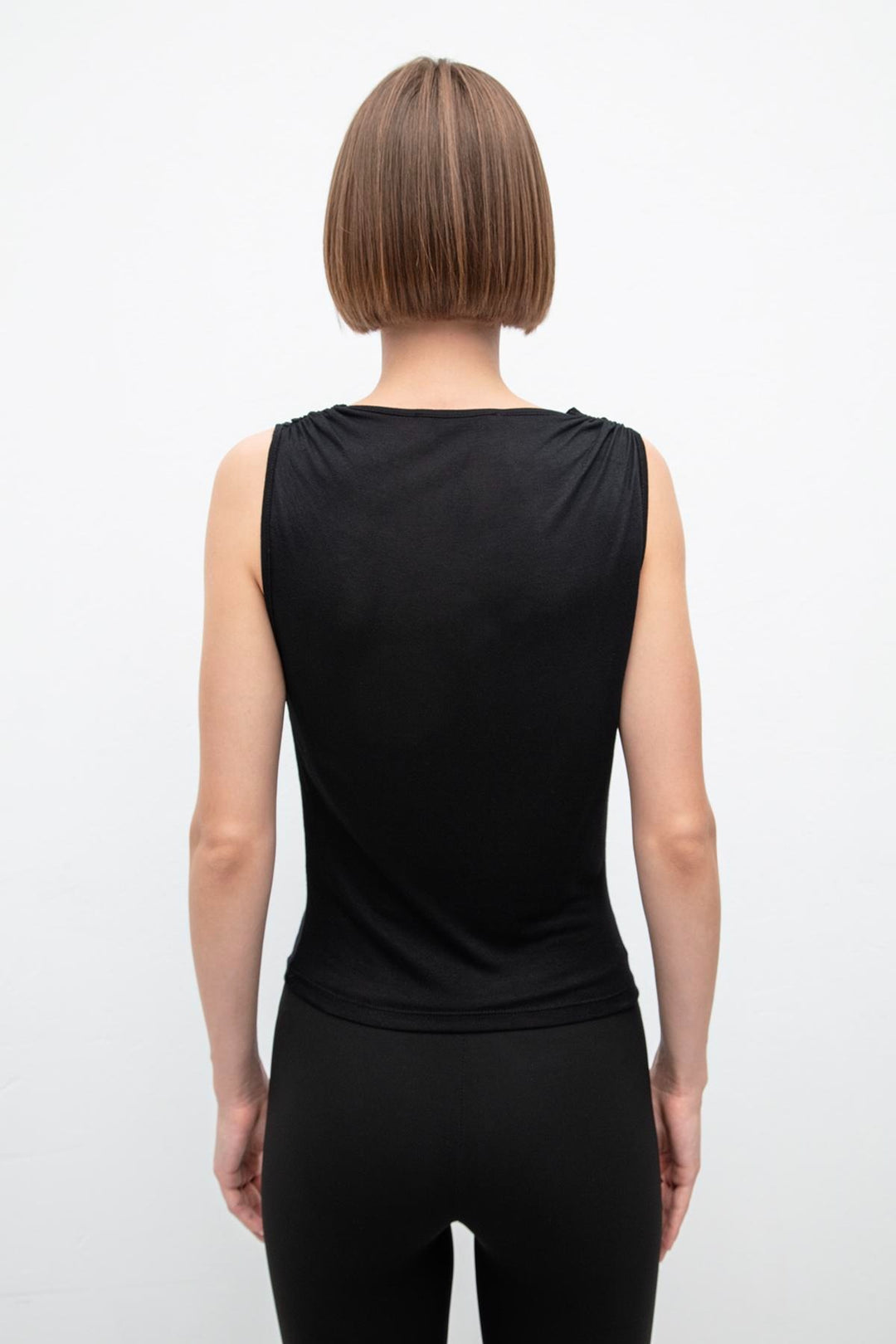 Back view of black viscose top featuring ruffle collar and relaxed fit – elegant design