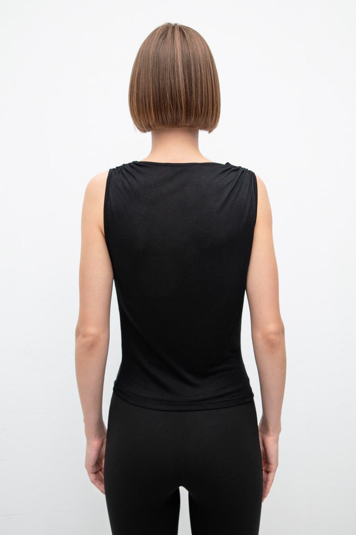 Back view of black viscose top featuring ruffle collar and relaxed fit – elegant design