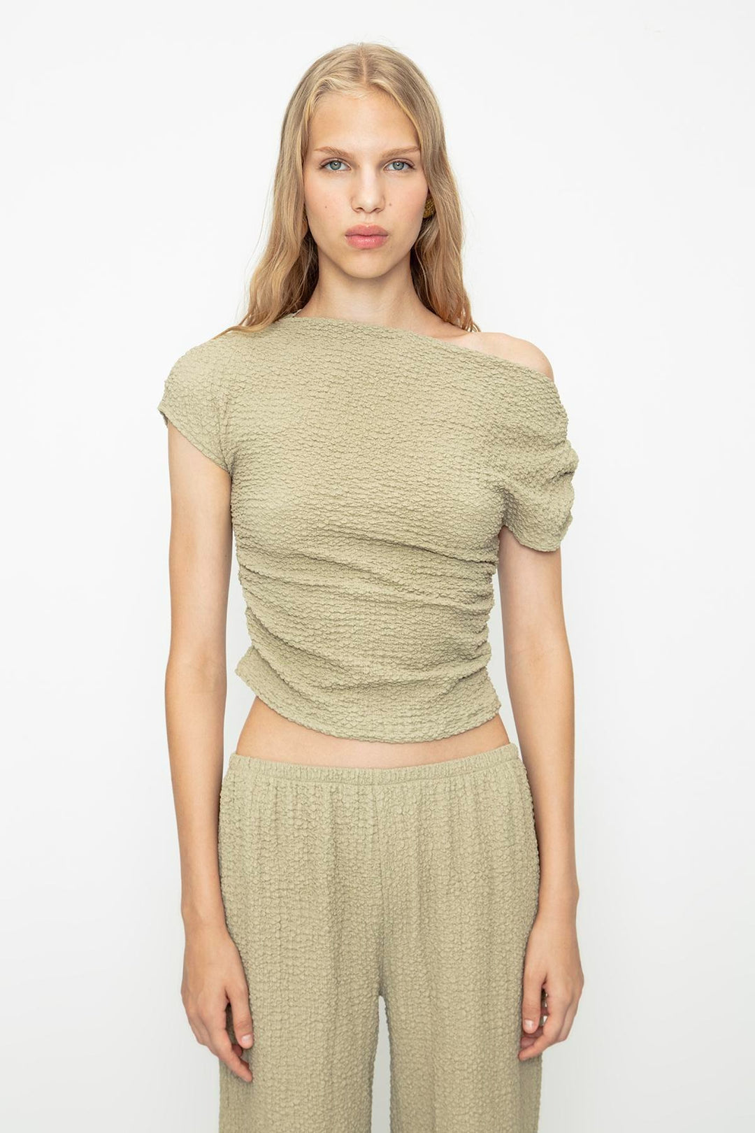 Chic outfit pairing khaki textured top with high-waisted trousers – perfect for casual elegance