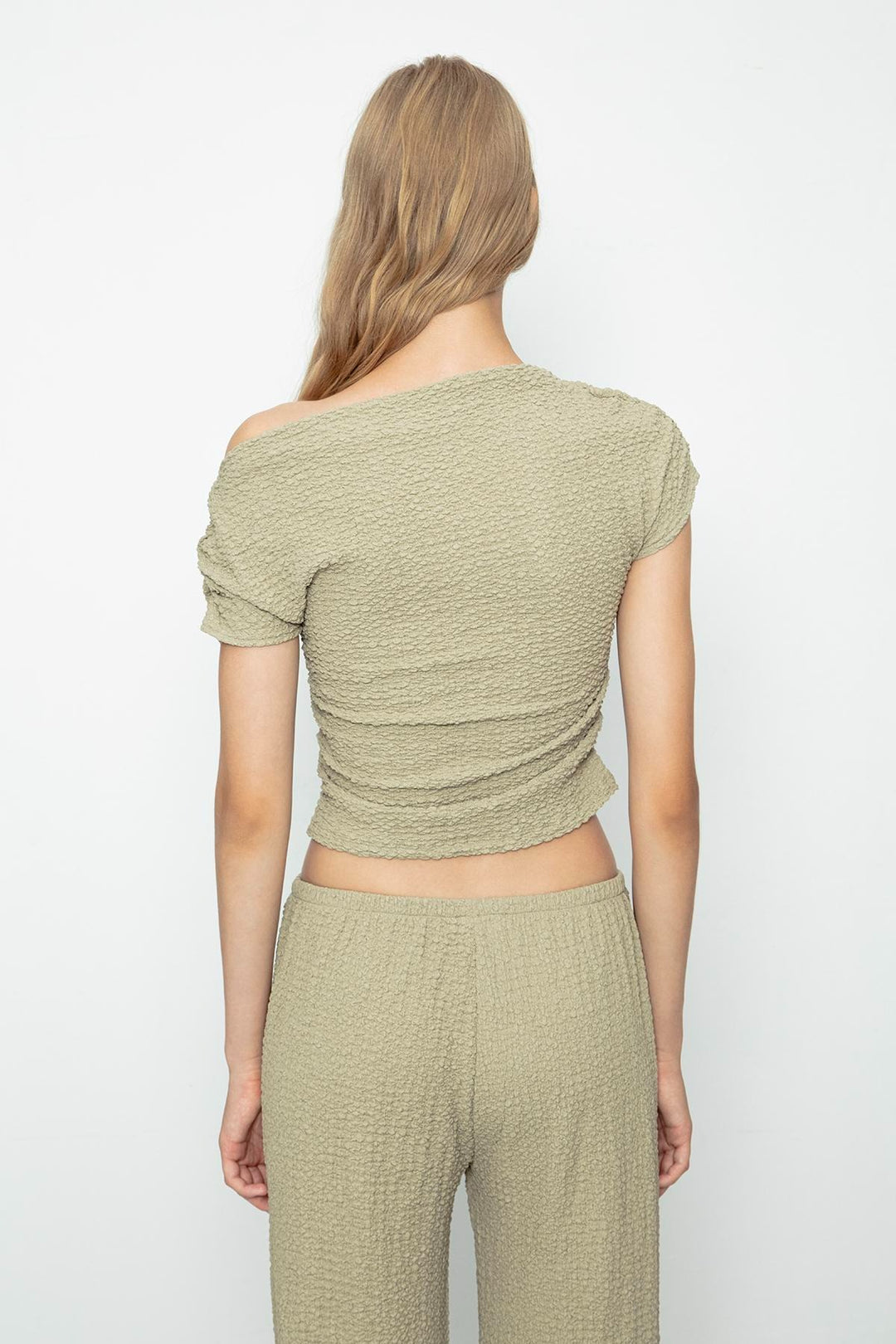 Chic outfit pairing khaki textured top with high-waisted trousers – perfect for casual elegance