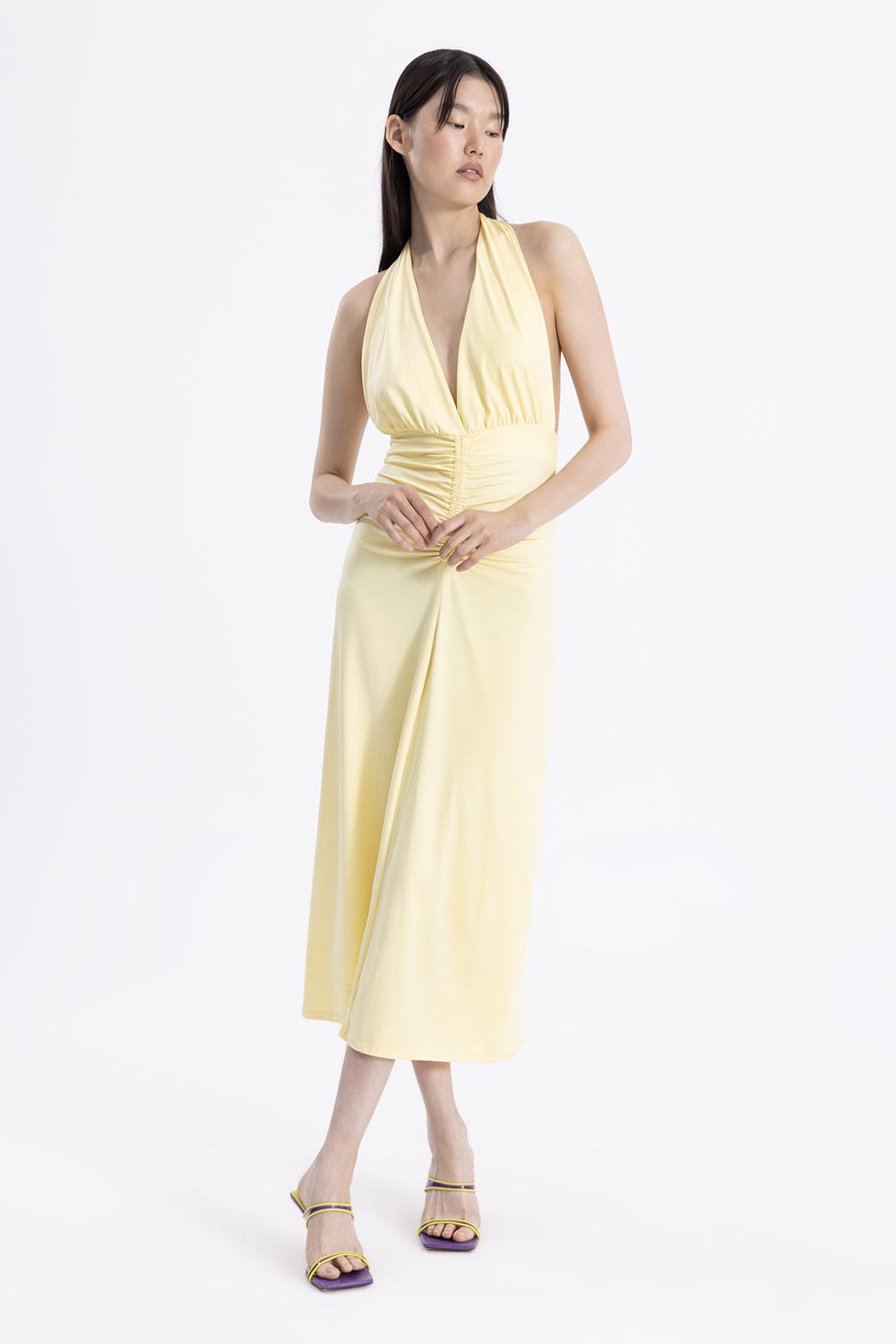 Chic outfit pairing butter yellow draped midi dress with strappy heels – perfect for summer elegance