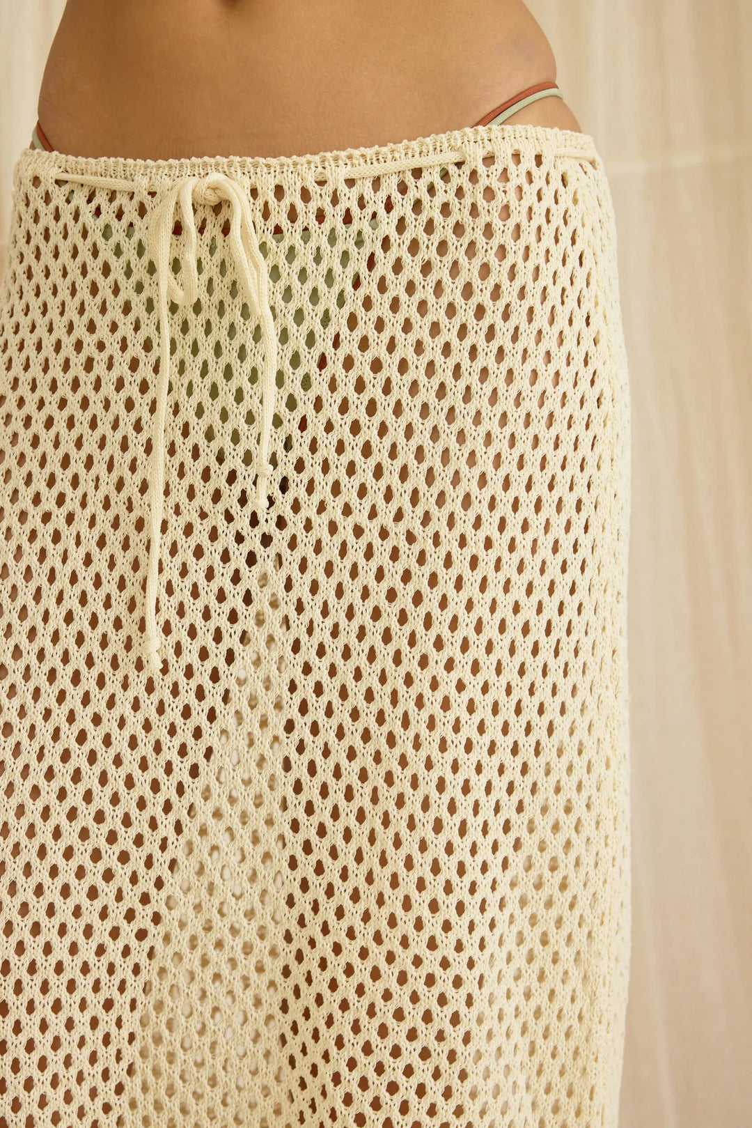 Beige crochet skirt with drawstring waist on a neutral background