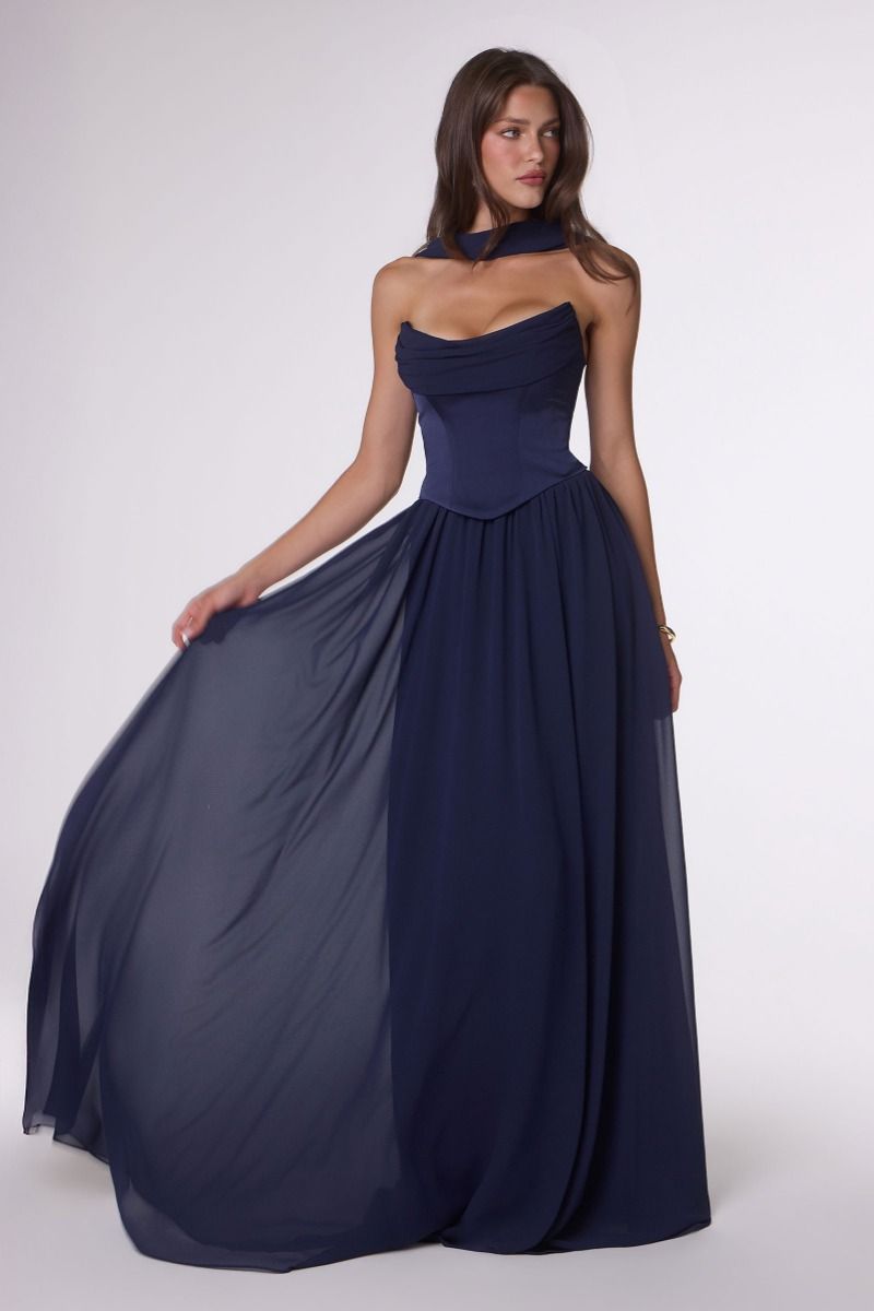 Woman wearing a navy blue strapless gown on a white background