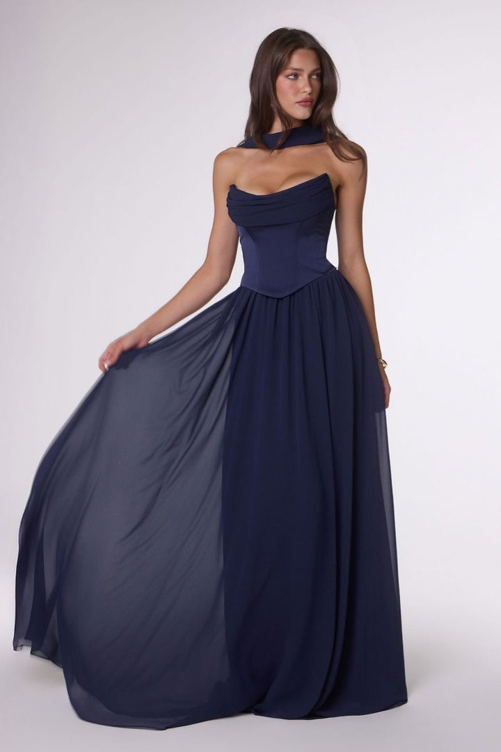 Woman wearing a navy blue strapless gown on a white background