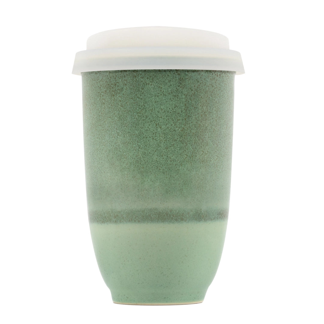 Green ceramic cup with a white lid on a white background