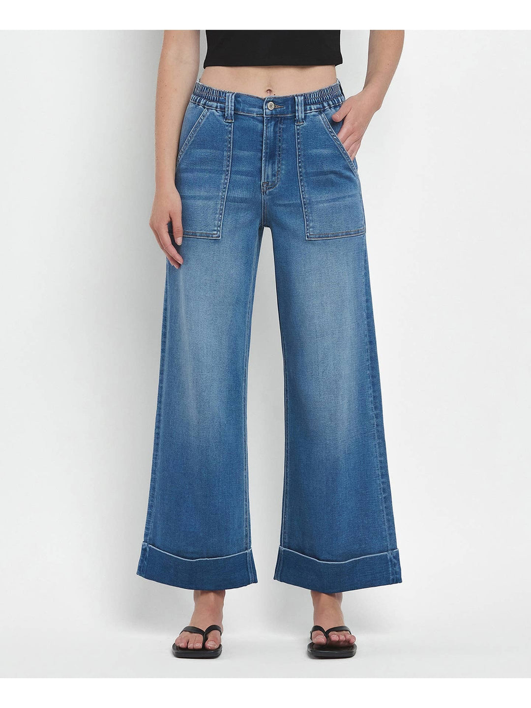 Person wearing blue wide-leg jeans on a white background