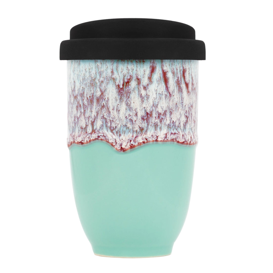 Turquoise ceramic travel mug with black lid on a white background