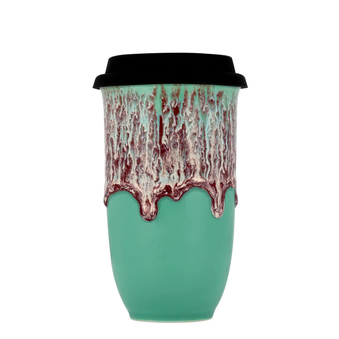 Green ceramic cup with black lid and red and white pattern on a white background
