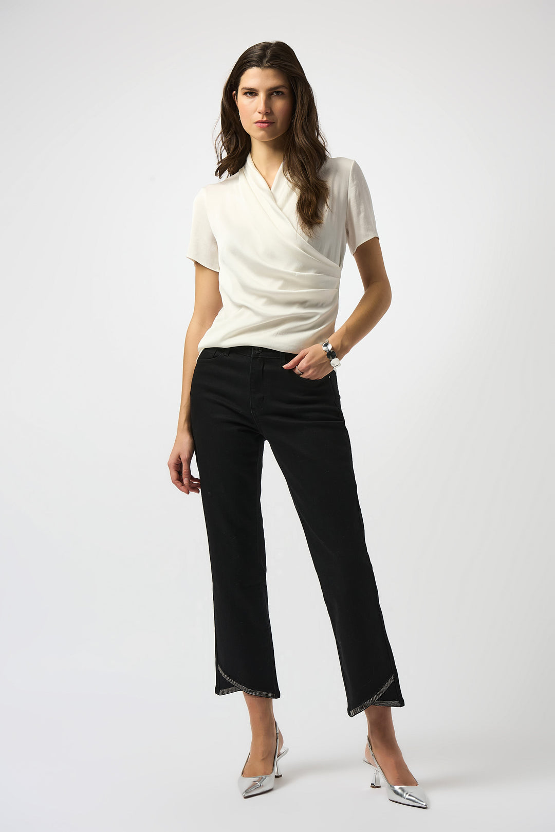 Woman wearing a white top and black pants on a white background