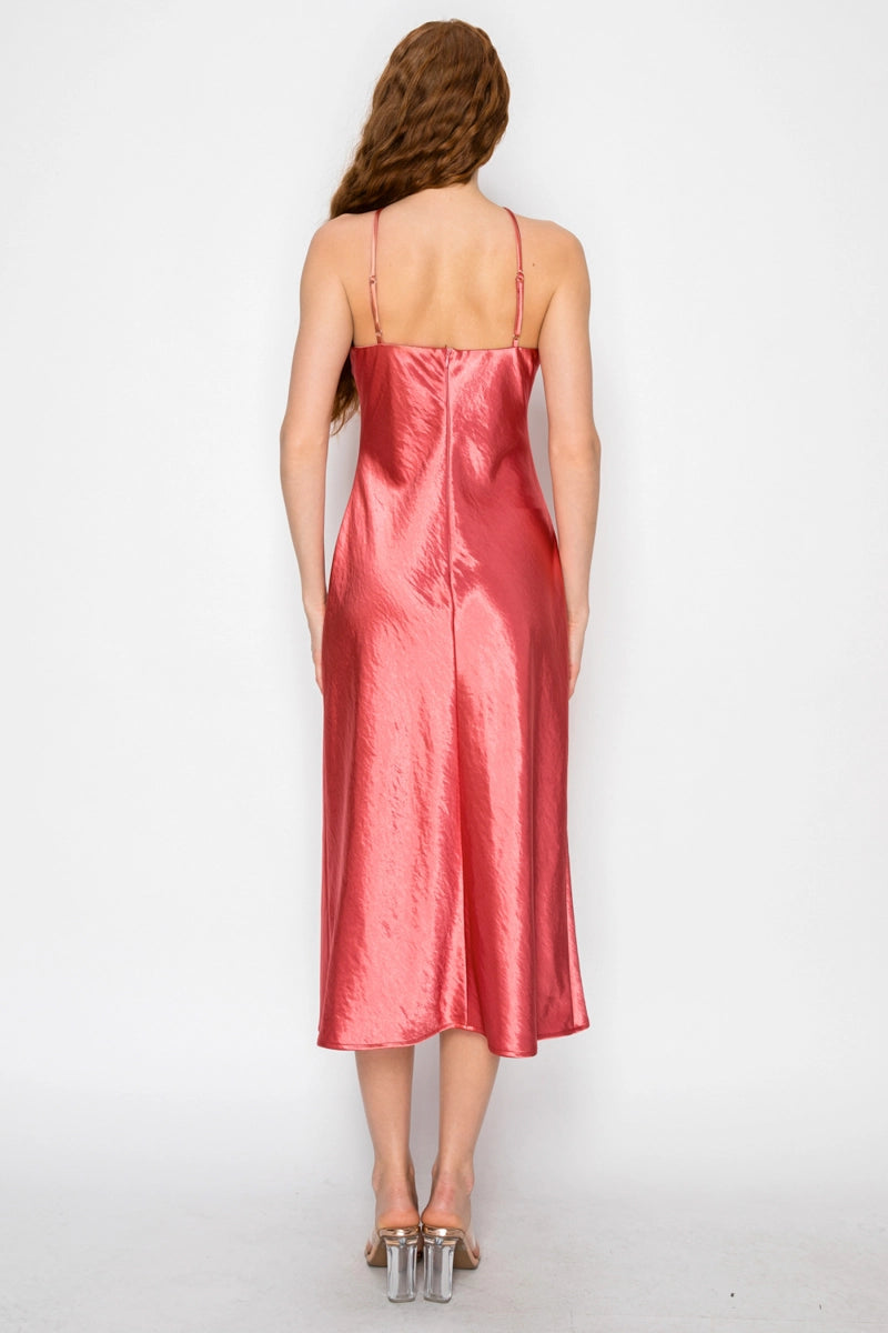 Woman wearing a pink satin slip dress on a white background