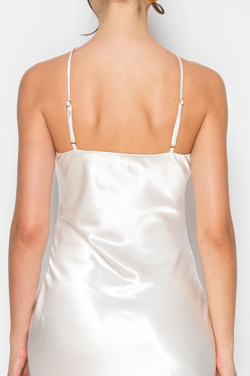 White satin slip dress worn by a person on a plain background
