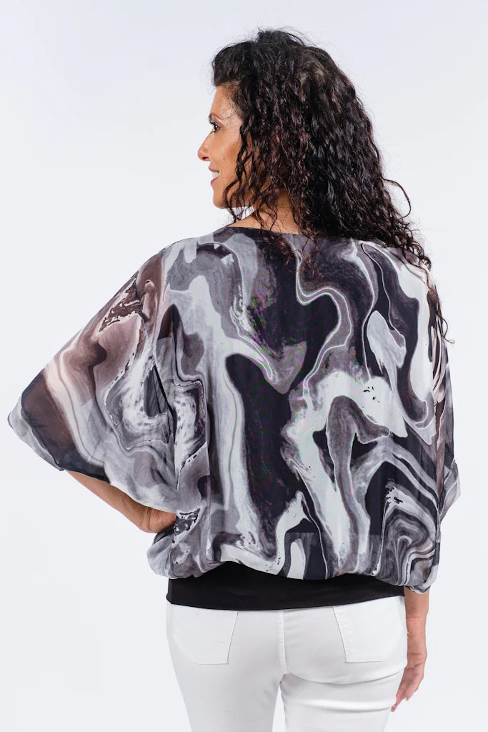 Back view of Italian-made black silk blouse featuring elegant swirl design and relaxed fit
