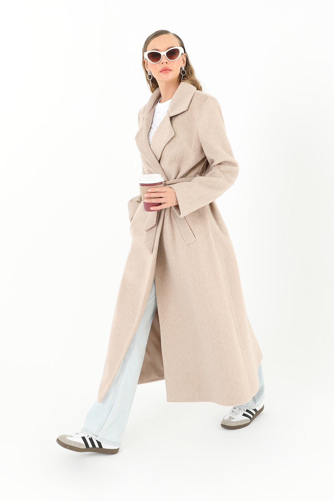 Woman wearing a beige trench coat on a white background