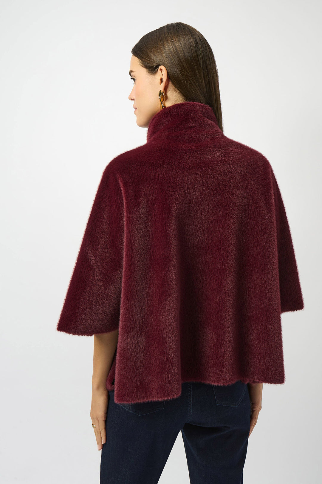Woman wearing a burgundy cape on a white background