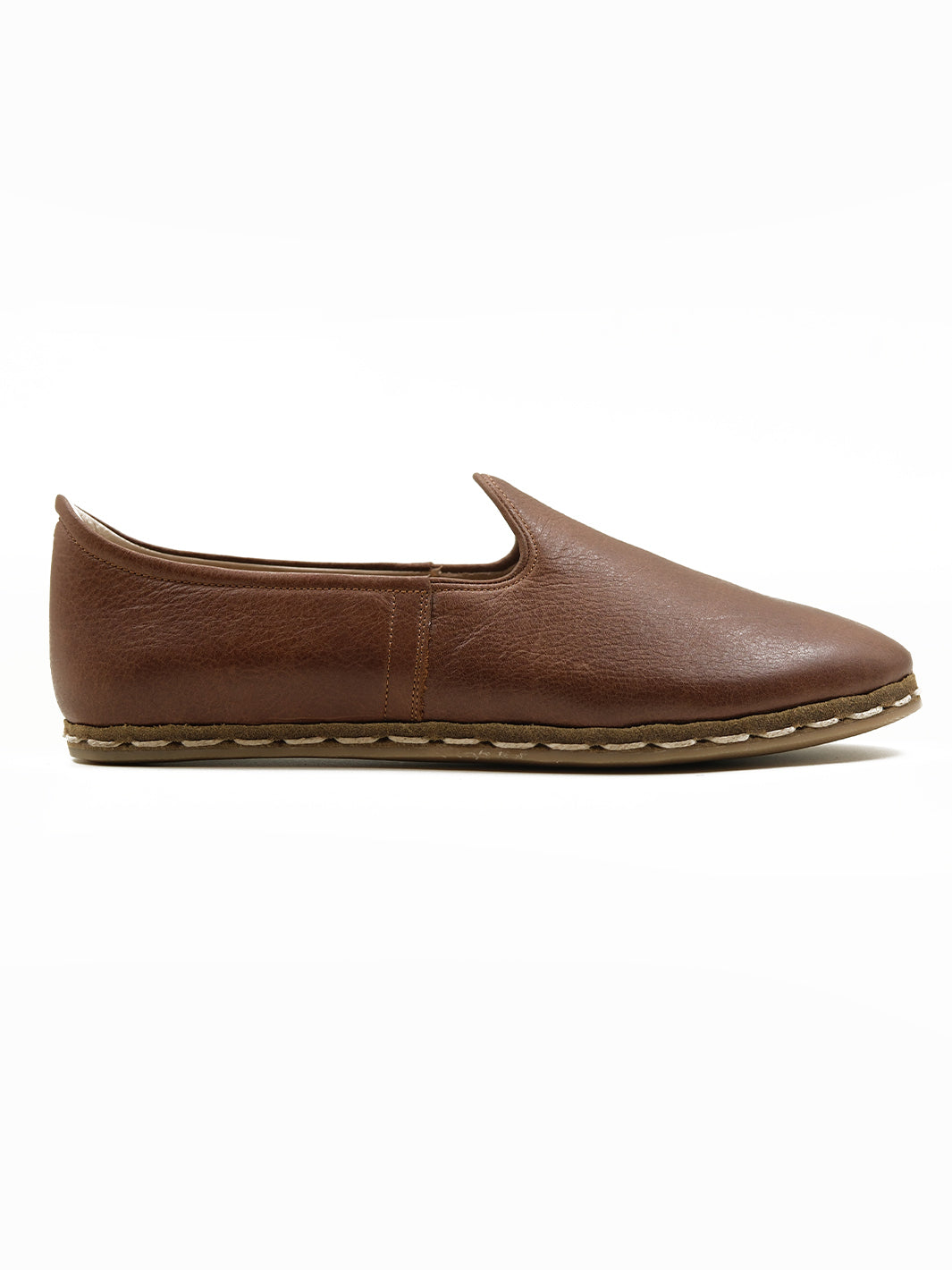 Close-up of beeswax-coated cotton twine stitching on handmade walnut brown leather slip-on​