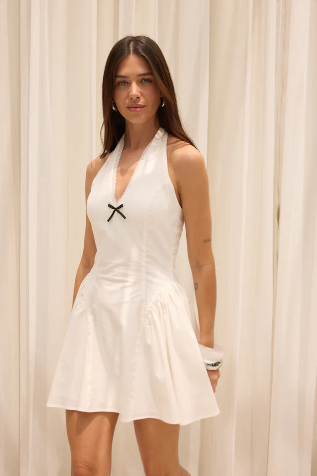 Woman wearing a white dress with a black &